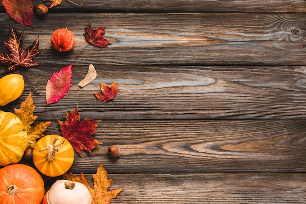 Autumn leaves with nuts on wooden table