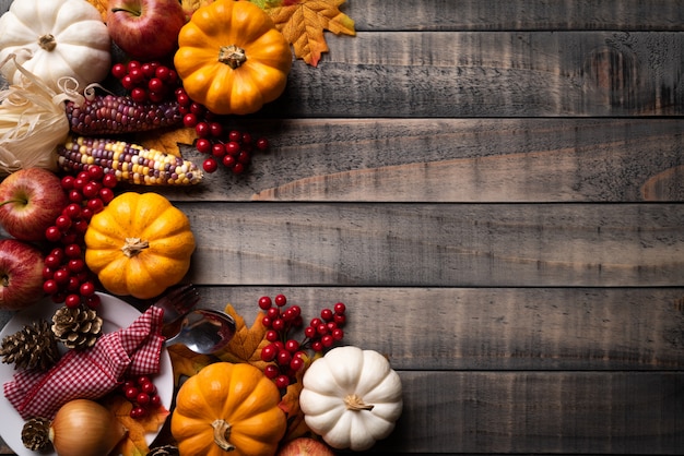 Autumn maple leaves with Pumpkin, corn and red berries