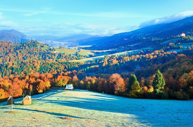 Autumn misty morning valley with stack of hay and village view (Mighgirya village outskirts, Carpathian Mt's, Ukraine).