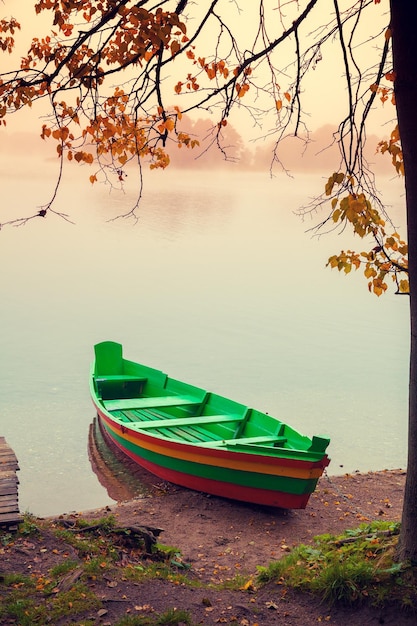 Autumn misty morning Wooden boat on the river bank