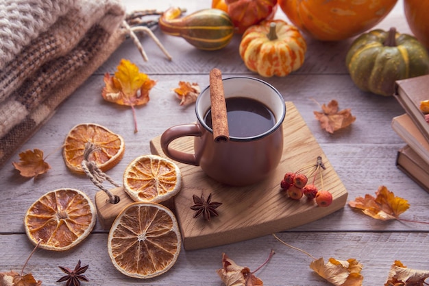 Autumn mood autumn atmosphere A cup of coffee pumpkins knitted warm blankets books autumn leaves on the windowsill