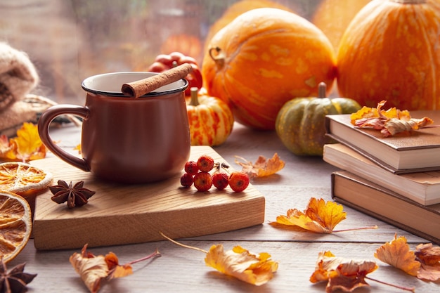 Autumn mood autumn atmosphere A cup of coffee pumpkins knitted warm blankets books autumn leaves on the windowsill