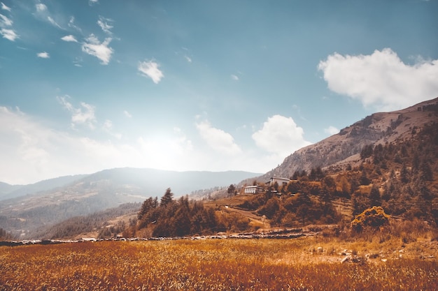 Autumn mountain valley against blue cloudy sky