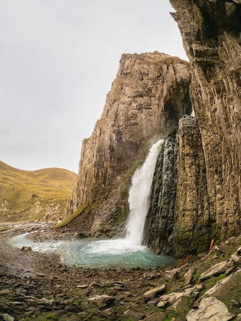 Autumn mountains in autumn morning GilSu waterfall in wide autumn valley in North Caucasus Russia Beautiful vertical landscape