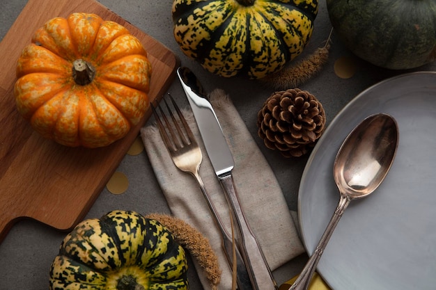 Autumn place setting lifestyle thanksgiving background with cutlery and pumpkins