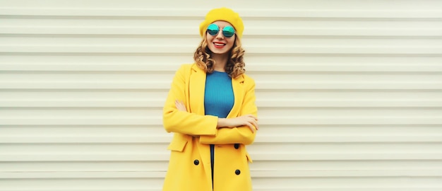 Photo autumn portrait of beautiful happy smiling woman in yellow french hat stylish trendy girl posing