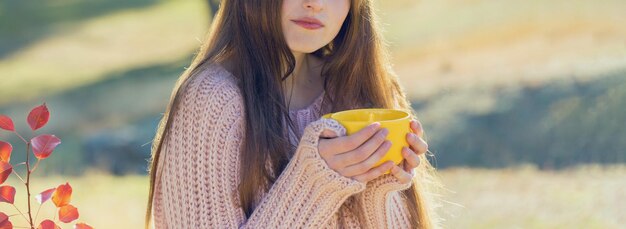 Autumn portrait of a girl with a yellow cup