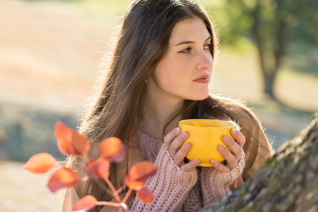 Autumn portrait of a girl with a yellow cup