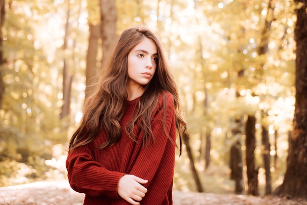 Autumn portrait smiling woman holds yellow maple leaves in park autumn landscape dreamy girl with lo