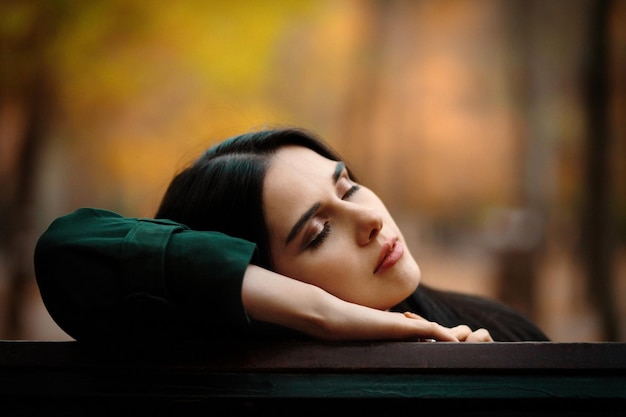 Autumn portrait of young dreaming girl with closed eyes in autumn park