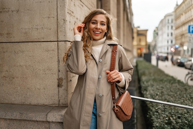 Autumn portrait of young fashionable woman wearing trendy coat in the street