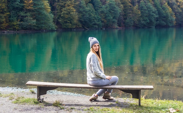 Autumn pretty girl posing near mountain lake. autumn lanscape in forest.