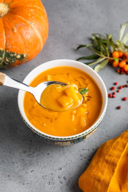 Autumn pumpkin cream soup with Rosemary and Paprika in dark wooden background