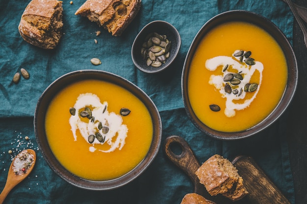 Autumn pumpkin creamy soup in bowls