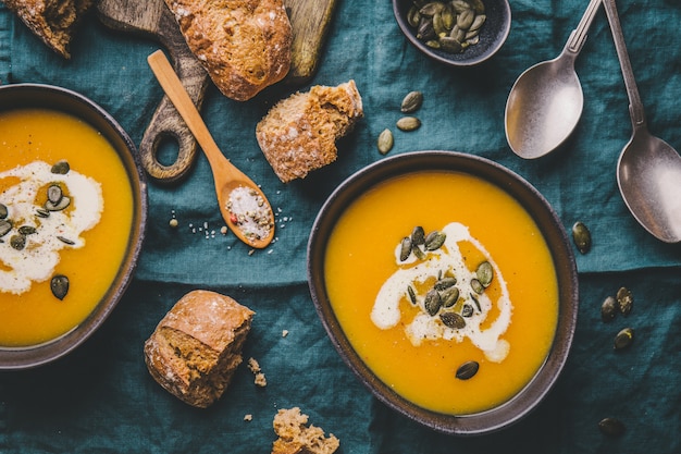 Autumn pumpkin creamy soup in bowls