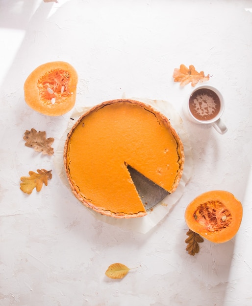 Autumn pumpkin pie Shortcrust tart with orange pumpkin cream on white concrete background