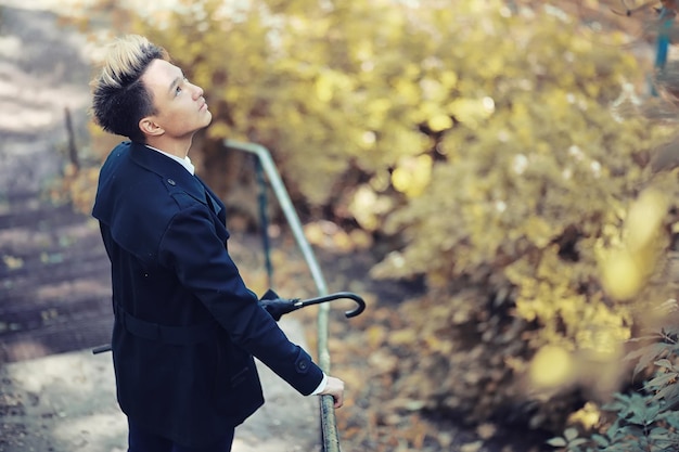 Autumn rainy weather and a young man with an umbrella