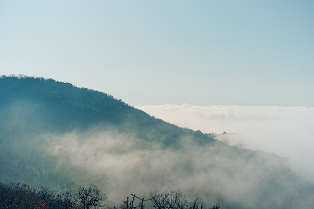 Autumn rural scenery with  mountains and forests covered with morning fog