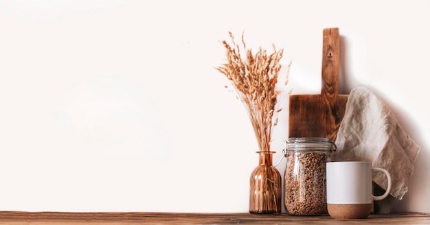 Autumn scene layout. a cup of coffee, wooden cutting boards and dried flowers in the sunlight.