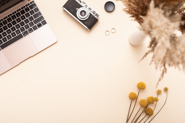 Photo autumn season fall concept. top view of laptop, vintage camera, yellow leaves background. minimal composition.