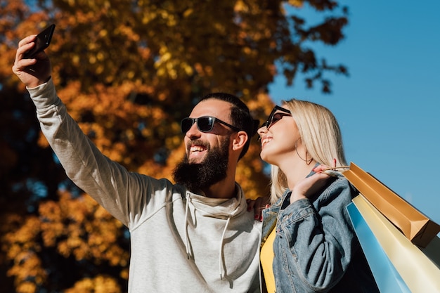 Autumn shopping travel Couple taking selfie on smartphone