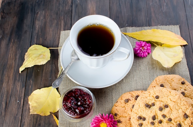 Autumn still life with cup of tea, biscuit  and leaves. 