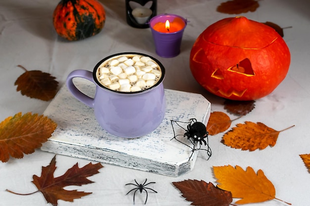 Autumn still life with pumpkins, candles, leaves and a cup of coffee on the table. Selective focus. Halloween concept