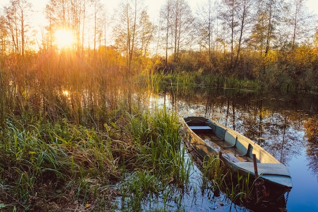 Autumn sunset on the river with a boat in the foreground