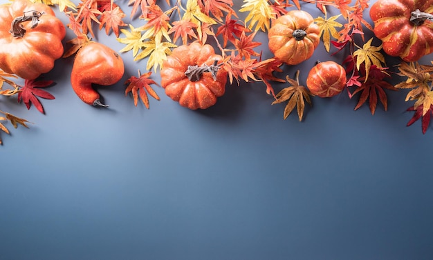 Autumn and thanksgiving decoration concept made from autumn leaves berry and pumpkin on pastel background Flat lay top view with copy space