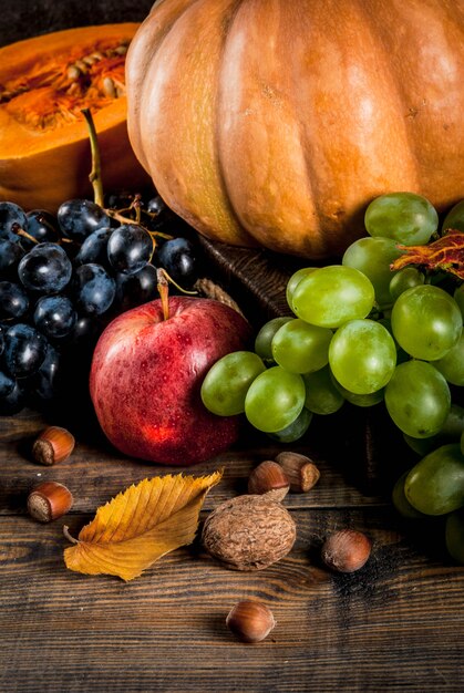 Autumn and thanksgiving harvest concept. Seasonal fall fruits and pumpkin on wooden table,  top view