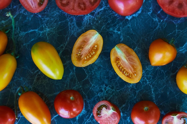 Autumn vegetables Colorful red orange and yellow tomatoes on green marble background Natural organic food Top view food