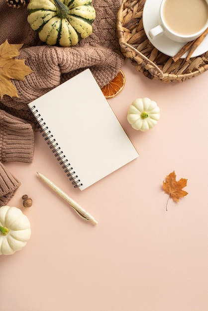 Photo autumn warmth setting from vertical top view cozy brown knitted plaid open diary with pen hot coffee pattypans cinnamon wicker basket maple leaves dried orange on pastel beige space for text