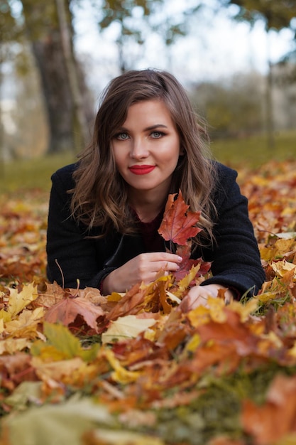 Autumn woman on colorful fall leaves background outdoors