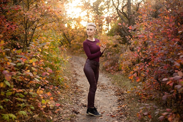 Autumn woman with autumn leaves Portrait of a charming and lovely girl Happy woman enjoying the autumn