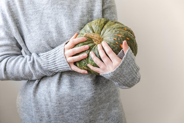 Autumnal Background Unrecognizable woman hand holding in hands autumn fall pumpkin isolated on white background Change of seasons ripe organic food Halloween party Thanksgiving day