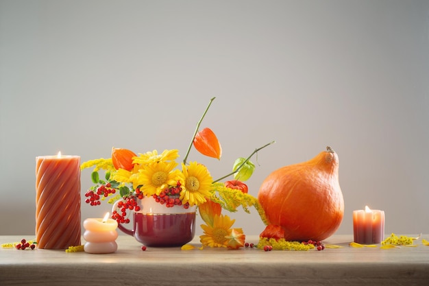 autumnal still life with flowers cones berries on wooden shelf