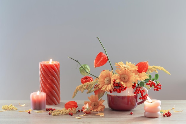 autumnal still life with flowers cones berries on wooden shelf