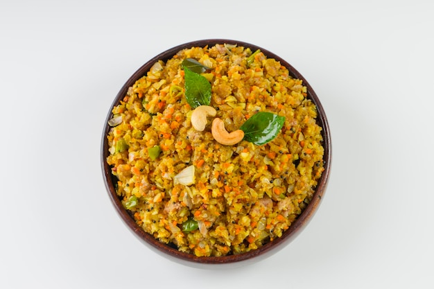 Aval upma or poha  upma or kanda poha upma,healthy indian breakfast item which is very tasty and easy to cook and it is arranged in a wooden bowl with white textured background.