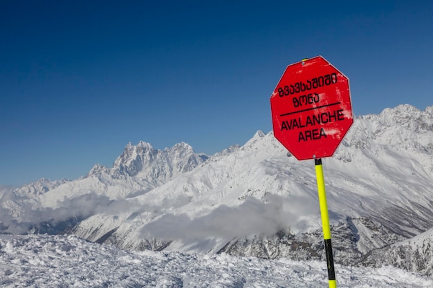 Avalanche terrain near a mountain slope The inscription on the red sign quotAvalanche cautionquot