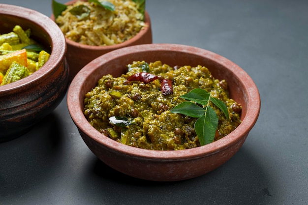 AvialKootu curry and Cabbage fryKerala traditional  side dishes which  is very healthy and tasty vegeterian  dishes arranged in an earthenwares with grey coloured background