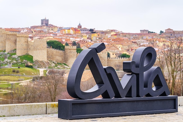 Avila city sign with background views of the walled city, Spain.