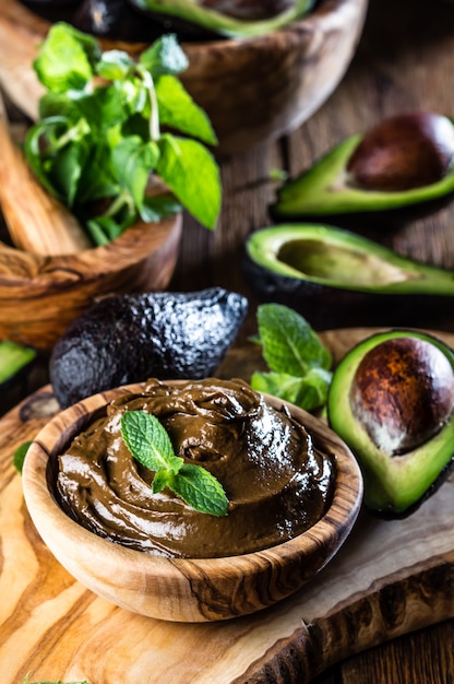 Avocado chocolate mousse in olive wooden bowl