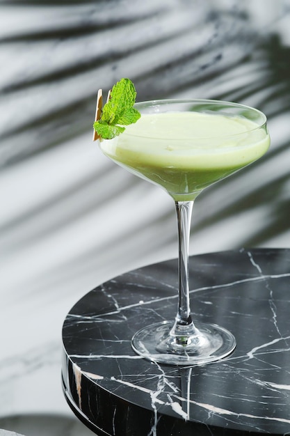 Avocado cocktail with leaf of mint on marble table and light background