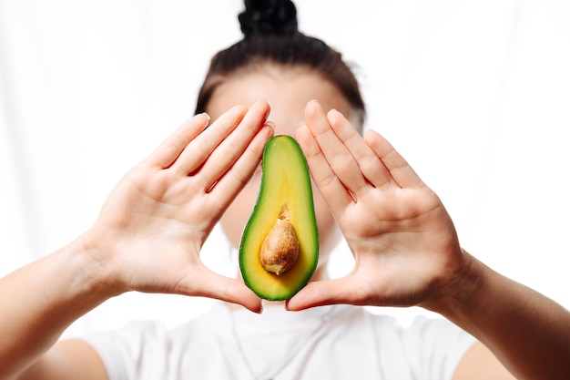 avocado in a female hand on a white background