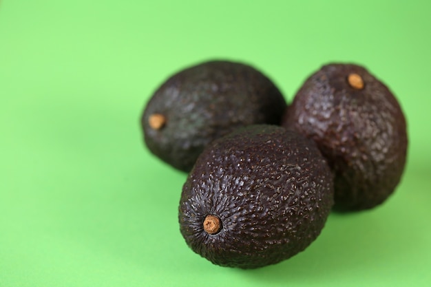 Avocado fruit. Three ripe avocados set on a light green table.Useful dietary product. Healthy Fat. Organic Bio Fresh Avocado