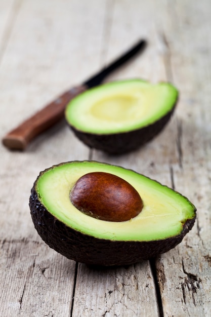 Avocado and knife on old wooden table 