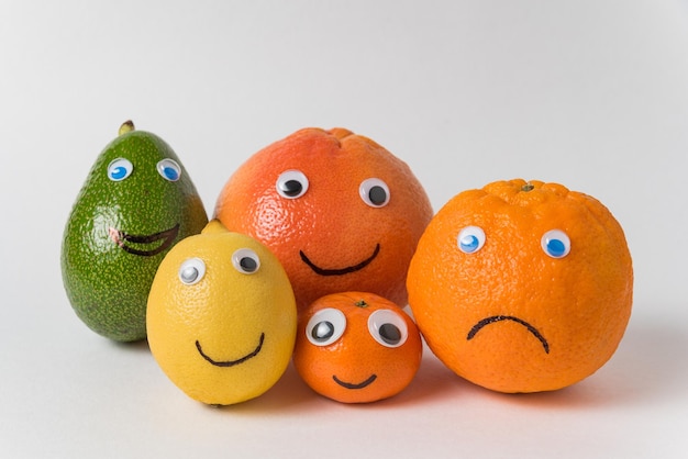 Avocado lemon orange tangerine and grapefruit with funny faces and Googly eyes Big family concept