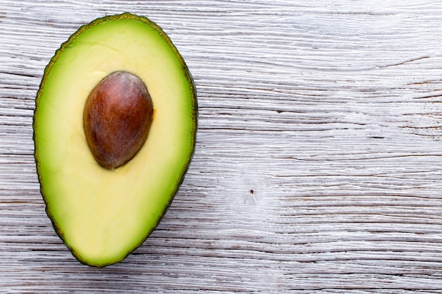 Avocado parts on the wooden table.