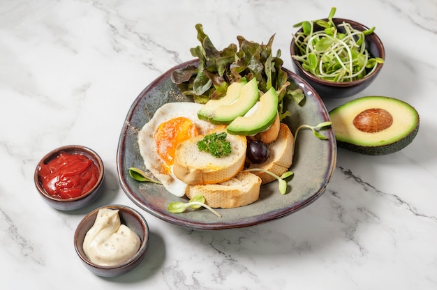 Avocado and sandwich with fried egg. Tree sliced avocado and fried egg on toasted bread for breakfast.