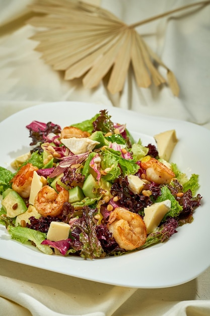 Avocado and shrimp salad in a white plate on a white tablecloth Hard light Selective focus